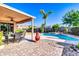 Outdoor living space with a covered patio, dining table, sparkling pool and lush landscaping at 2189 W Mila Way, San Tan Valley, AZ 85144
