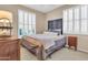Cozy bedroom with large windows, plantation shutters, and comfortable furnishings at 2189 W Mila Way, San Tan Valley, AZ 85144