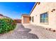 Exterior view of the home, showcasing the gravel landscaping, garage, and side of the house under a clear blue sky at 2189 W Mila Way, San Tan Valley, AZ 85144