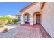 Charming front porch with arched entryway, brick pavers, and seating area, perfect for enjoying the outdoors at 2189 W Mila Way, San Tan Valley, AZ 85144