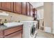 Well-equipped laundry room featuring a sink, cabinetry, and modern washer and dryer at 2189 W Mila Way, San Tan Valley, AZ 85144