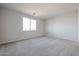 Bright, carpeted bedroom with a large window, providing ample natural light at 22045 N Rummler Ln, Maricopa, AZ 85138