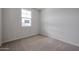 This bedroom features a window for natural light and neutral carpeting at 22045 N Rummler Ln, Maricopa, AZ 85138
