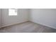 This bedroom offers neutral carpeting and a window providing natural light at 22045 N Rummler Ln, Maricopa, AZ 85138