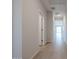 Hallway with light-colored tile flooring and multiple doorways at 22045 N Rummler Ln, Maricopa, AZ 85138
