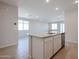 A kitchen island with a stainless steel dishwasher overlooks the adjacent living room and a wall of windows at 22045 N Rummler Ln, Maricopa, AZ 85138