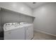 Well-lit laundry room with white appliances and ample shelving at 22045 N Rummler Ln, Maricopa, AZ 85138