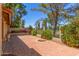 View of the backyard patio with red brick flooring, wrought iron fencing, and a circular fire pit area at 2322 S Rogers -- # 1, Mesa, AZ 85202