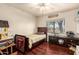 Well-lit bedroom featuring wood floors, ceiling fan, window and built-in shelves at 2322 S Rogers -- # 1, Mesa, AZ 85202