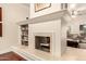 Living room with a fireplace and hearth, featuring built-in bookshelves and access to the backyard at 2322 S Rogers -- # 1, Mesa, AZ 85202