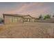 The backyard shows a patio and rock landscaping, with a block wall and a sunset sky at 2323 W Kachina Trl, Phoenix, AZ 85041