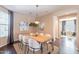 Charming dining room with a wooden table, white chairs, modern chandelier, and stylish decor at 2323 W Kachina Trl, Phoenix, AZ 85041