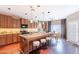 Open kitchen featuring a granite island with seating, wood cabinets, and a dining area at 2323 W Kachina Trl, Phoenix, AZ 85041
