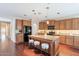 Spacious kitchen showcasing a granite island, wood cabinetry, and contemporary lighting at 2323 W Kachina Trl, Phoenix, AZ 85041