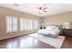 Bright main bedroom featuring wood floors, a ceiling fan, plantation shutters, and natural light at 2323 W Kachina Trl, Phoenix, AZ 85041