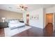 Bright main bedroom featuring wood floors, a ceiling fan, plantation shutters, and natural light at 2323 W Kachina Trl, Phoenix, AZ 85041