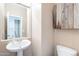 This is a well lit powder room with a pedestal sink, commode, and rustic wooden cabinet at 2323 W Kachina Trl, Phoenix, AZ 85041