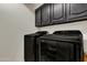 Well-equipped laundry room with dark cabinets and modern washer and dryer units at 2333 E Egret Ct, Gilbert, AZ 85234