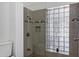 A shower featuring glass block windows, grey tiling and bronze fixtures at 2633 S El Dorado Dr, Mesa, AZ 85202