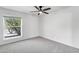 Minimalist bedroom with carpet, ceiling fan, and a large window with a view of the street at 2633 S El Dorado Dr, Mesa, AZ 85202