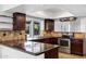 Stylish kitchen featuring dark wood cabinets, granite countertops, and stainless appliances at 2633 S El Dorado Dr, Mesa, AZ 85202