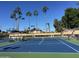 Well-maintained tennis court with bright blue surface and tall palm trees in the background at 2633 S El Dorado Dr, Mesa, AZ 85202