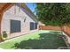 Lush backyard with artificial turf, mature tree, and a home with shaded windows at 26814 N 65Th Dr, Phoenix, AZ 85083