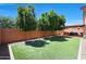 Beautiful backyard features a well-maintained artificial lawn, mature trees, and a charming pergola with an outdoor dining area at 26814 N 65Th Dr, Phoenix, AZ 85083