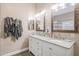 Bright bathroom featuring granite counters, dual sinks, rustic wood-framed mirrors, and fresh neutral paint at 26814 N 65Th Dr, Phoenix, AZ 85083