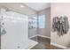 Modern bathroom with a glass enclosed shower, neutral paint, sleek shelving and wood look floors at 26814 N 65Th Dr, Phoenix, AZ 85083