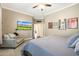 Spacious bedroom with a TV, chair, and a view into an open doorway at 26814 N 65Th Dr, Phoenix, AZ 85083
