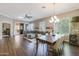 Open-concept living room boasts a large sectional, wood floors, and a dining area with a modern chandelier at 26814 N 65Th Dr, Phoenix, AZ 85083