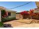 Backyard featuring a bricked patio, a deck, and colorful bougainvillea, offering a private and relaxing outdoor space at 2926 W San Miguel Ave, Phoenix, AZ 85017