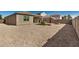 Large gravel-covered backyard with a fire pit, outdoor dining set, and lush synthetic turf at 30238 N Ocotillo Dr, Florence, AZ 85132