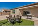 Charming backyard space with artificial grass, an outdoor table, seating, and a grill at 30238 N Ocotillo Dr, Florence, AZ 85132