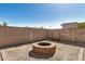 Enclosed backyard features brick fire pit with gravel and block wall surround, perfect for outdoor entertaining at 30238 N Ocotillo Dr, Florence, AZ 85132