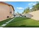 Expansive backyard with lush lawn, stone pavers, landscaping, and a view of the pool and seating area at 3295 S Ambrosia Dr, Chandler, AZ 85248