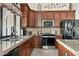 Well-equipped kitchen with stainless steel appliances, granite countertops, and dark wood cabinetry at 3295 S Ambrosia Dr, Chandler, AZ 85248