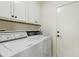 Efficient laundry area featuring a washer, dryer, cabinets, and a convenient ironing setup near the exit door at 3295 S Ambrosia Dr, Chandler, AZ 85248