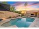 Inviting backyard pool area with lush landscaping, patio seating, desert sunsets, and a tall palm tree at 3295 S Ambrosia Dr, Chandler, AZ 85248