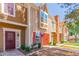 A view of a tan townhome highlighting the red door and window trim at 3416 W Julie Dr # 4, Phoenix, AZ 85027