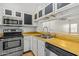 Cozy kitchen featuring stainless steel appliances, white cabinets, and wood countertops at 3416 W Julie Dr # 4, Phoenix, AZ 85027