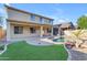 Backyard pool featuring rock waterfall, outdoor patio, green grass, and a home with covered patio at 3535 W Morgan Ln, San Tan Valley, AZ 85144