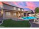 Backyard pool featuring rock waterfall, outdoor patio, green grass, and a home with covered patio at 3535 W Morgan Ln, San Tan Valley, AZ 85144