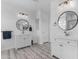 Bright bathroom featuring double vanities, round mirrors, modern lighting and wood-look floors at 3535 W Morgan Ln, San Tan Valley, AZ 85144