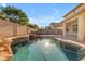 Beautiful in-ground pool with rock waterfall feature, backyard landscaping, and brick patio at 3535 W Morgan Ln, San Tan Valley, AZ 85144