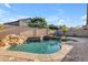 Beautiful backyard pool with rock waterfall feature, brick patio, and backyard landscaping at 3535 W Morgan Ln, San Tan Valley, AZ 85144
