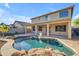 Backyard pool featuring rock waterfall and a covered patio with exterior views of a two story stucco home at 3535 W Morgan Ln, San Tan Valley, AZ 85144