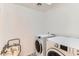 Functional laundry room with white washer and dryer, accented by a unique black and white patterned floor at 3555 E Morenci Rd, San Tan Valley, AZ 85143