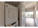 Hallway view of stacked washer and dryer featuring a white door leading to the balcony at 3600 N Hayden Rd # 3002, Scottsdale, AZ 85251